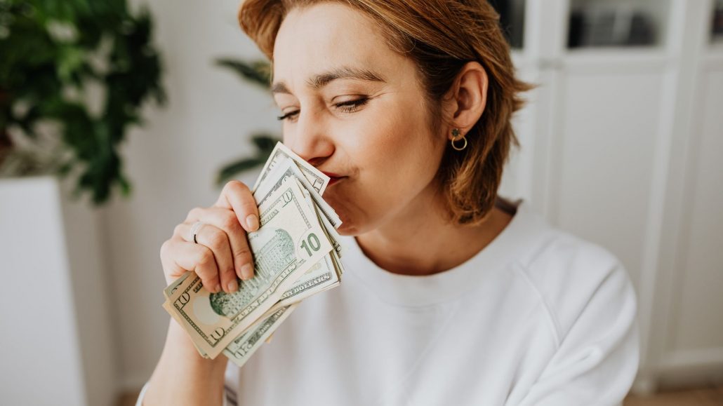 how to stop overspending money. Woman smelling money